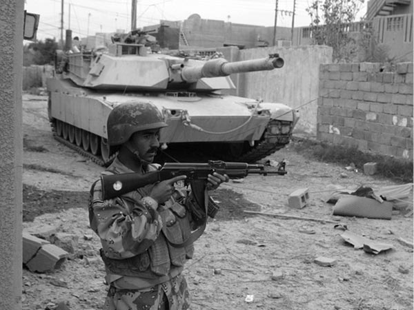 An Iraqi soldier and an M1A1 Abrams tank provide security for Marine ground forces during Operation Al-Fajr, 11 December 2004.